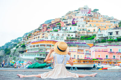 Rear view of woman against buildings in city
