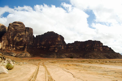 Rock formations on landscape against cloudy sky