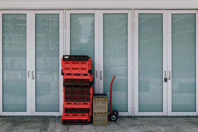 Crates on footpath by glass door