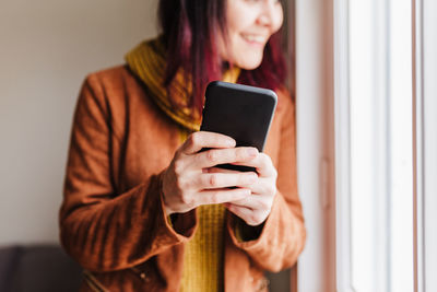 Young woman using mobile phone at home