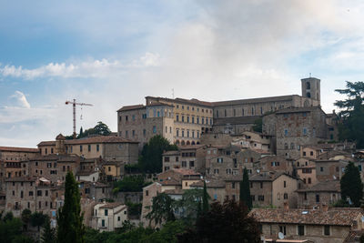 Buildings in city against cloudy sky