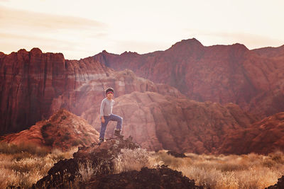 Little boy hiking on the peak looking over.