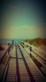 Boardwalk on beach against sky