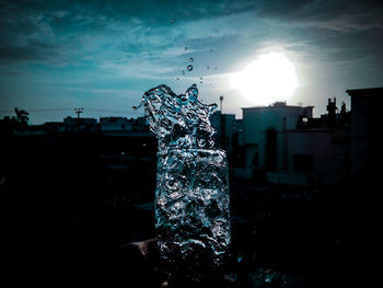 Fountain in city against sky