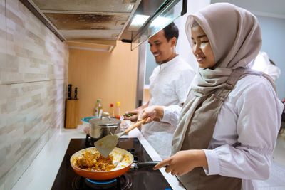 Side view of young couple holding food