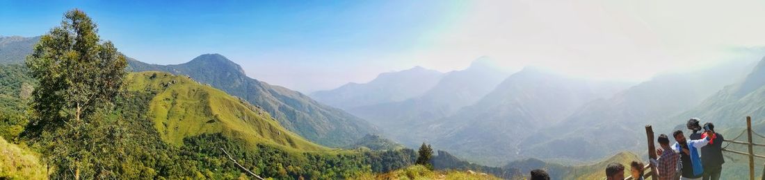 Panoramic shot of people on mountain range against sky