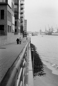 Rear view of a man walking with horse in background