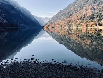 Scenic view of lake by mountains against sky