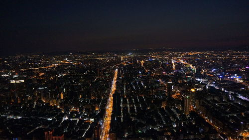 Illuminated cityscape against sky at night