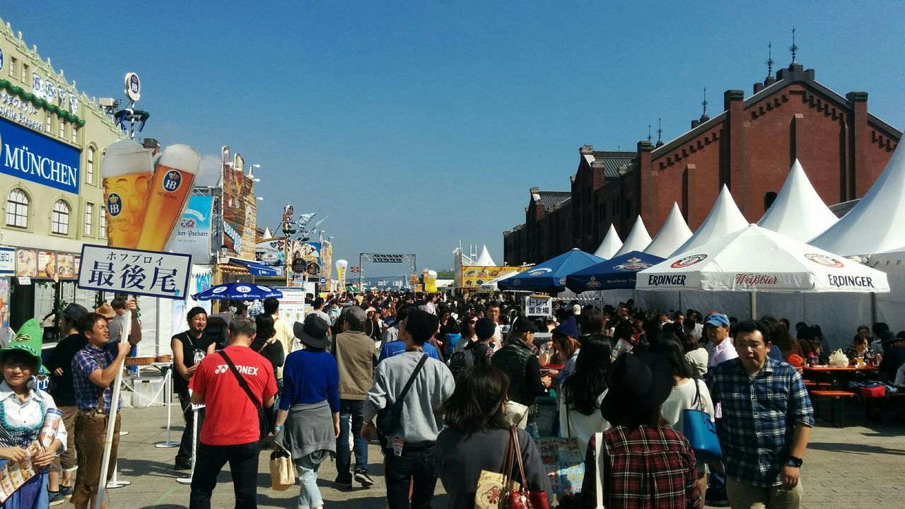 large group of people, building exterior, architecture, built structure, person, men, clear sky, crowd, city, lifestyles, street, city life, mixed age range, walking, leisure activity, crowded, market, outdoors, blue