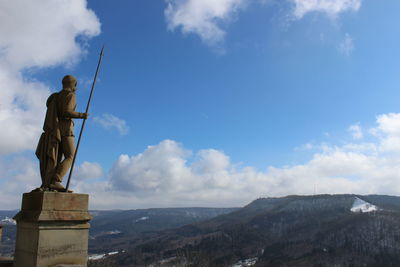 Statue on mountain against sky