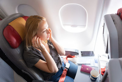 High angle view of businesswoman sitting in plane