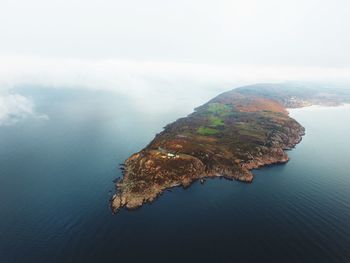 Scenic view of sea and mountains against sky