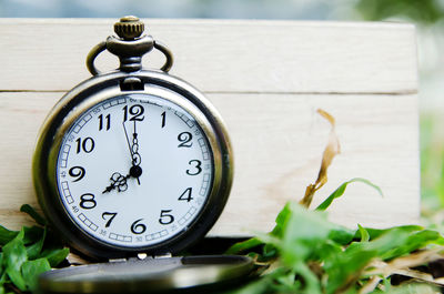 Close-up of clock on wooden bench