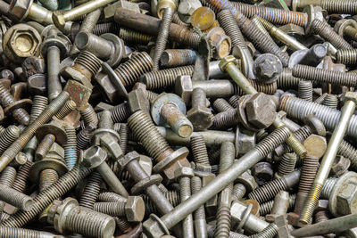 Full frame background of used automobile bolts heap, old and dirty