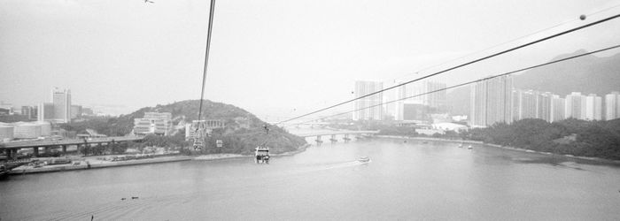 Bridge over river in city against clear sky