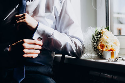 Midsection of men sitting by window