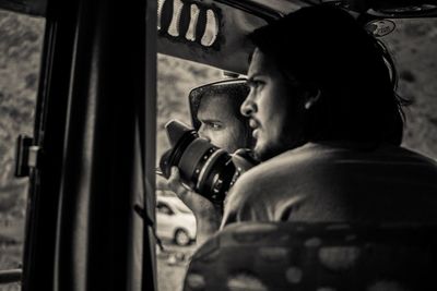 Man holding camera in vehicle