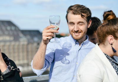 Portrait of a smiling young man drinking glass