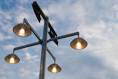 Low angle view of illuminated street light against sky