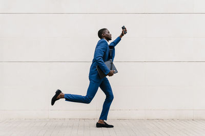 Full length of man photographing on wall