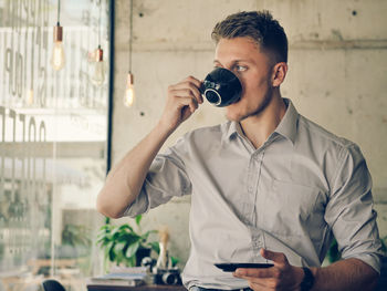 Young man photographing with mobile phone