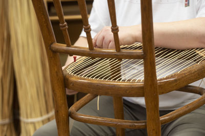 Midsection of man making chair