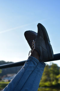 Low section of man against blue sky