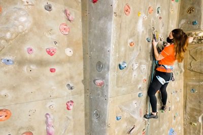 High angle view of woman climbing on wall