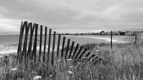 Wooden posts on beach against sky