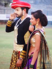 Side view of young couple standing outdoors