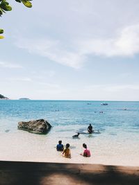 People on beach against sky