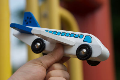 Close-up of hand holding toy airplane