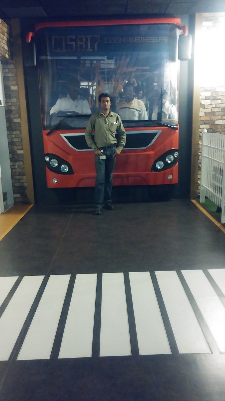 PORTRAIT OF MAN STANDING IN CORRIDOR OF BUILDING