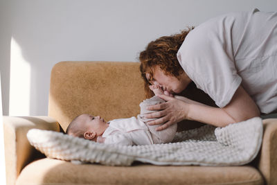 Portrait of happy mum holding infant child on hands.