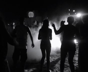 People standing on street at night