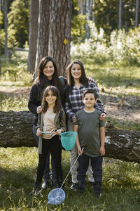 Portrait of a smiling girl standing against trees