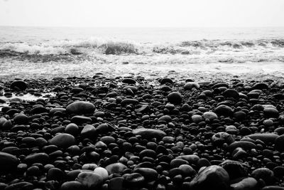 Stones on beach against sky