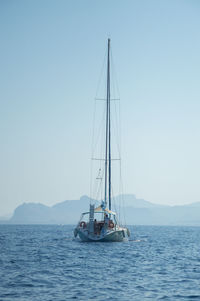 Sailboat sailing on sea against clear sky