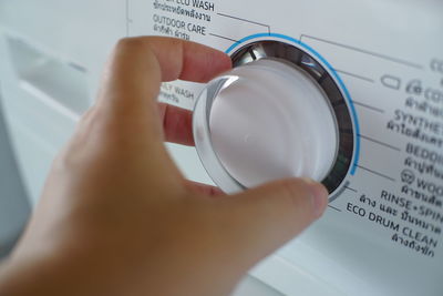 Close-up of hand adjusting washing machine