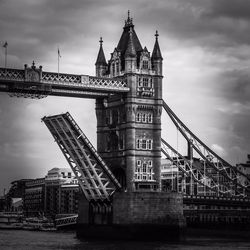 Bridge over river against cloudy sky