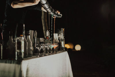 Low angle view of wine glass bottles and barmen show