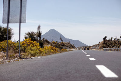 Road by mountain against sky