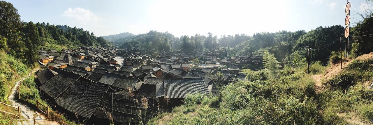 tree, panoramic, architecture, built structure, building exterior, mountain, sky, residential district, town, growth, nature, tranquility, community, tranquil scene, scenics, rural scene, valley, beauty in nature, outdoors, day, wide, agriculture, farm, wide shot, no people, human settlement, tourism