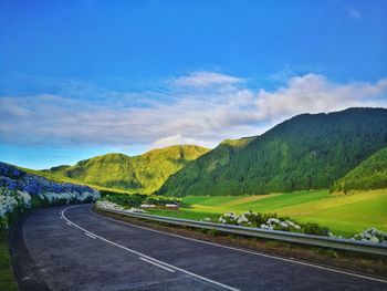 Road leading towards mountains against sky