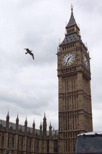 Low angle view of clock tower against cloudy sky