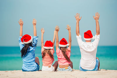 Group of people at beach against sky