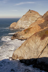 Rock formation on beach against sky