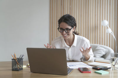 Businesswoman using laptop while sitting on table