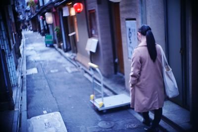 Rear view of woman walking on street in city